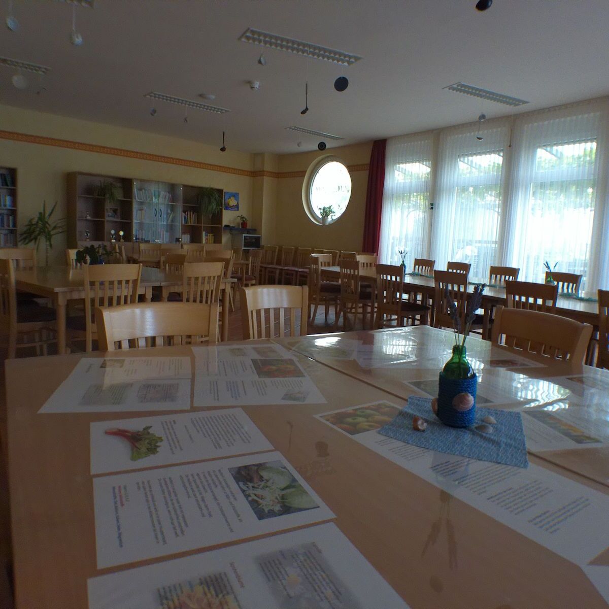 Im Speisesaal wurden Zettel ausgeteilt und liegen auf den langen Tischen.