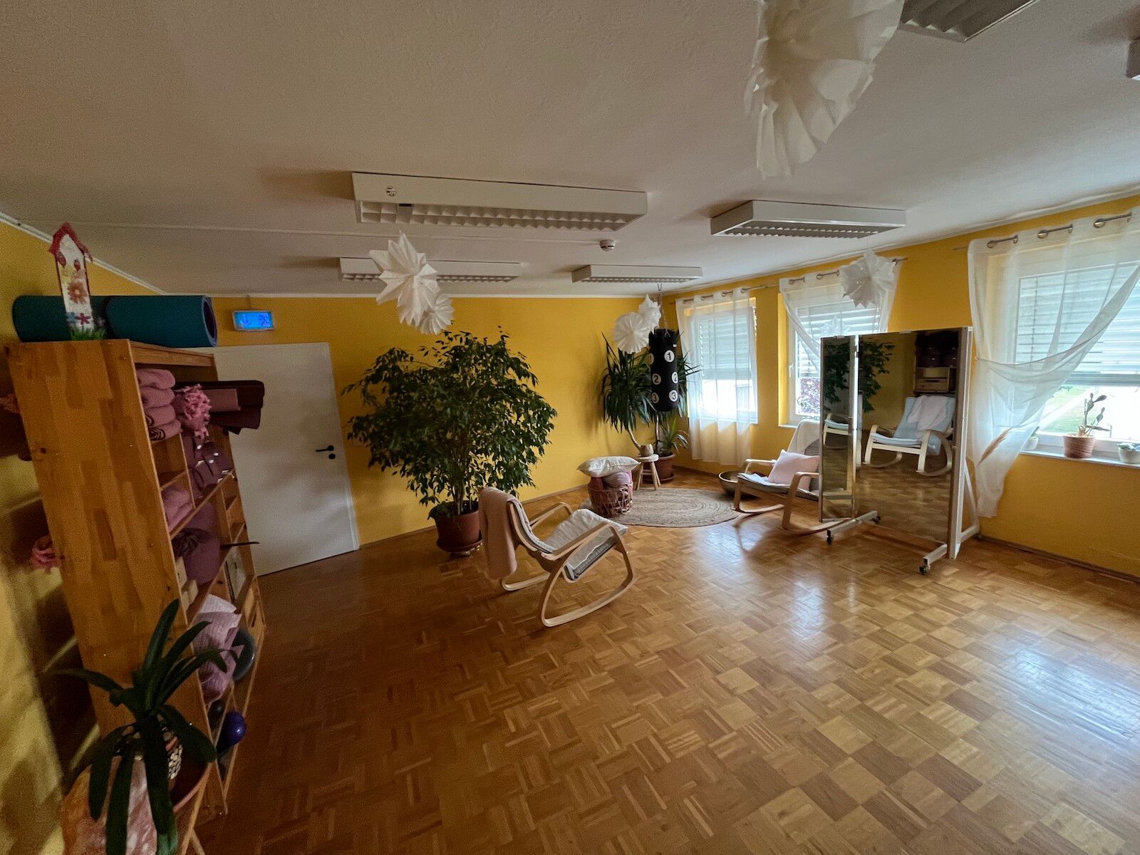 Der Schranke und die Sitzecke sind zu sehen. Im Schrank sind Jogamatten, Handtücher, viele Schubfächer.