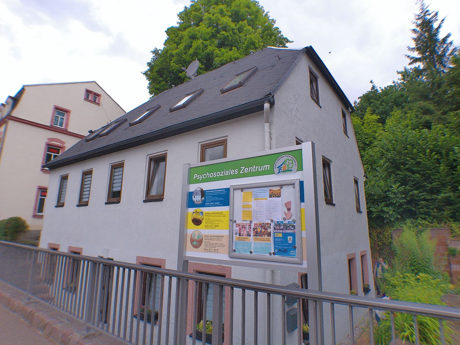 Ein Haus, davor steht ein Schild darauf geschrieben steht Psychosoziales Zentrum